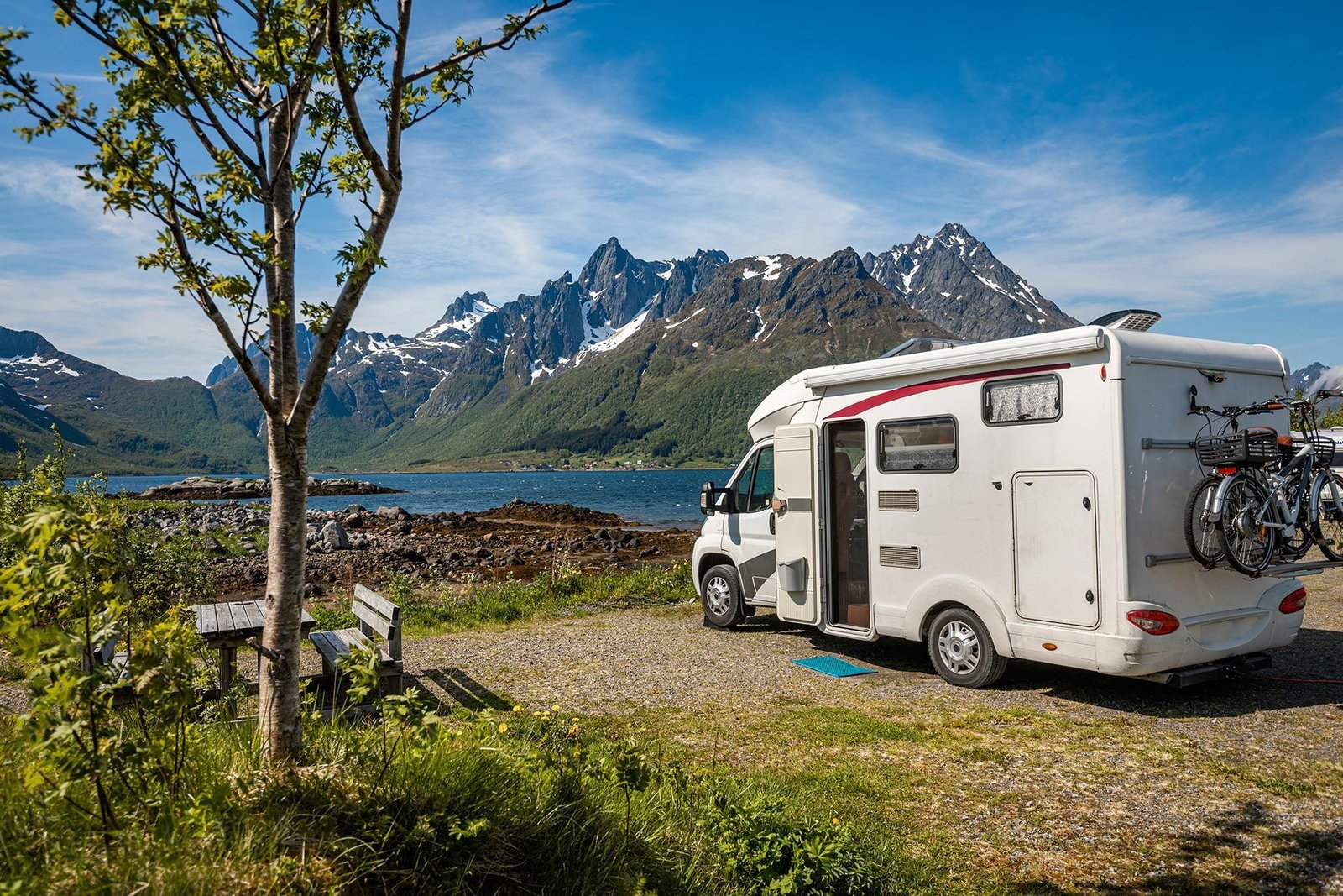 Wohnmobil an einem See vor einer Berglandschaft